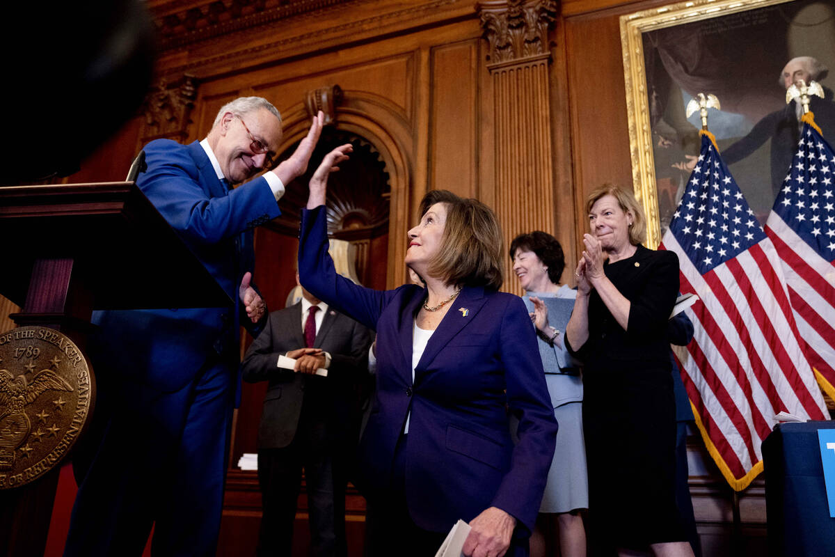 Senate Majority Leader Sen. Chuck Schumer of N.Y., left, high-fives House Speaker Nancy Pelosi ...