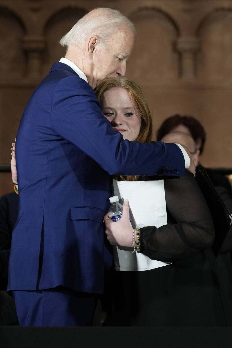 President Joe Biden hugs Sandy Hook survivor Jackie Hegarty, who introduced him, during an even ...