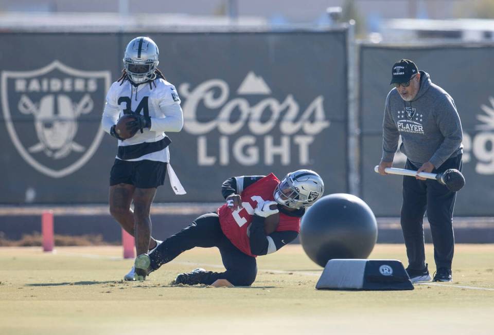 Raiders running back Josh Jacobs (28) rolls through a drill with coach Kennedy Polamalu instruc ...