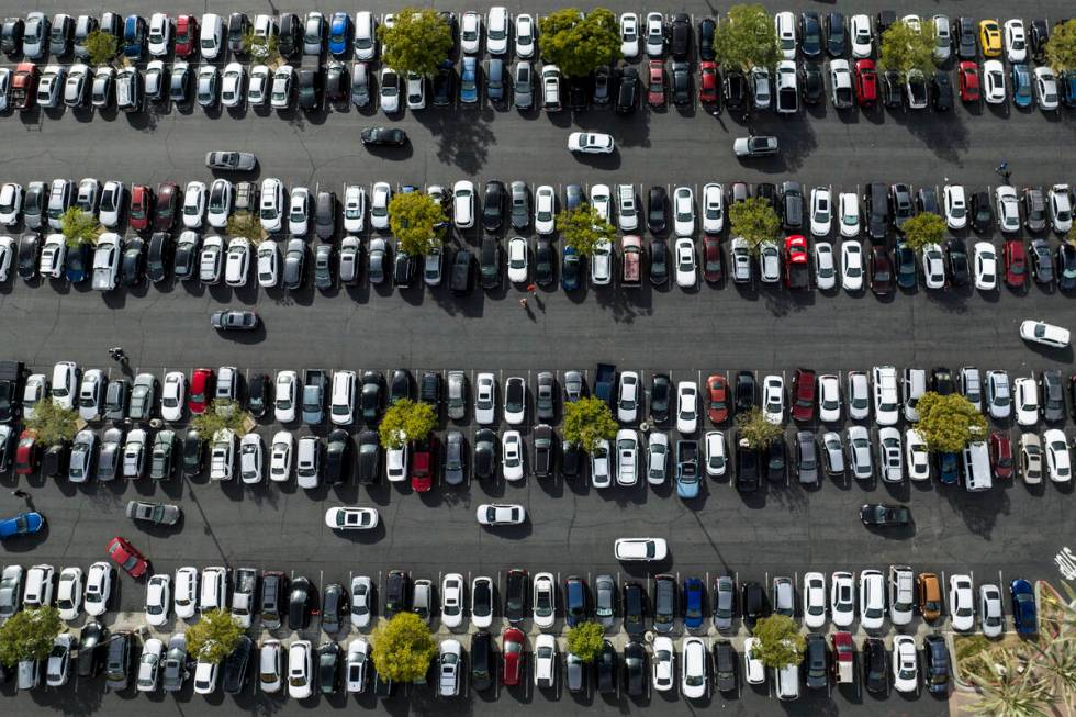 FILE - In this photo taken by a drone, motorists look for an open space to park in the parking ...