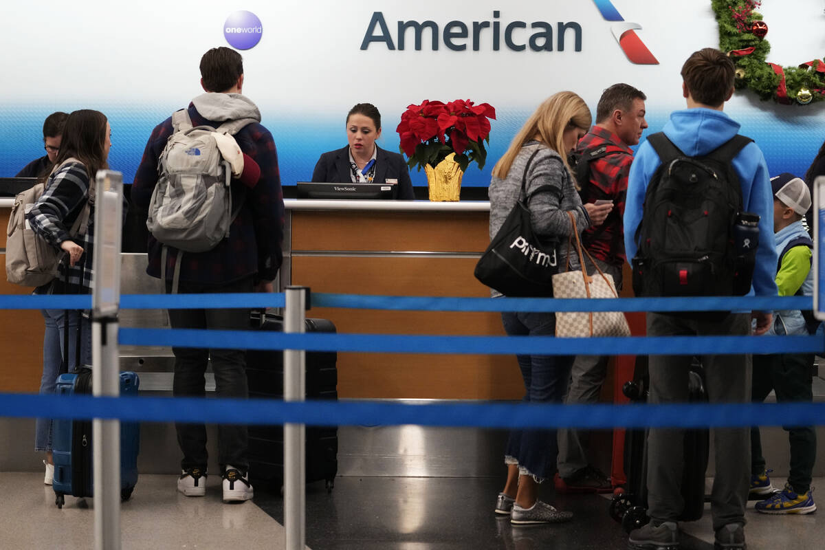 FILE - Travelers check in at an airline ticket counter at O'Hare International Airport in Chica ...