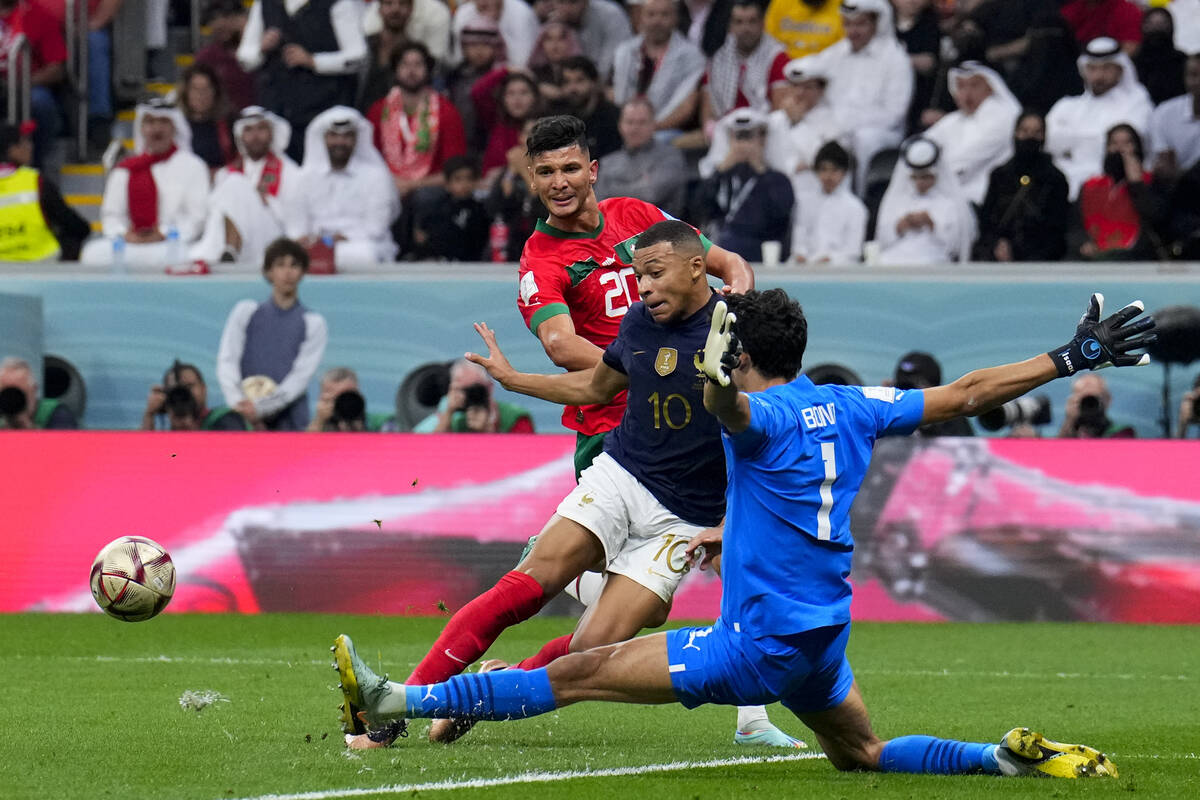 Morocco's goalkeeper Yassine Bounou cuts off and attack of France's Kylian Mbappe during the Wo ...