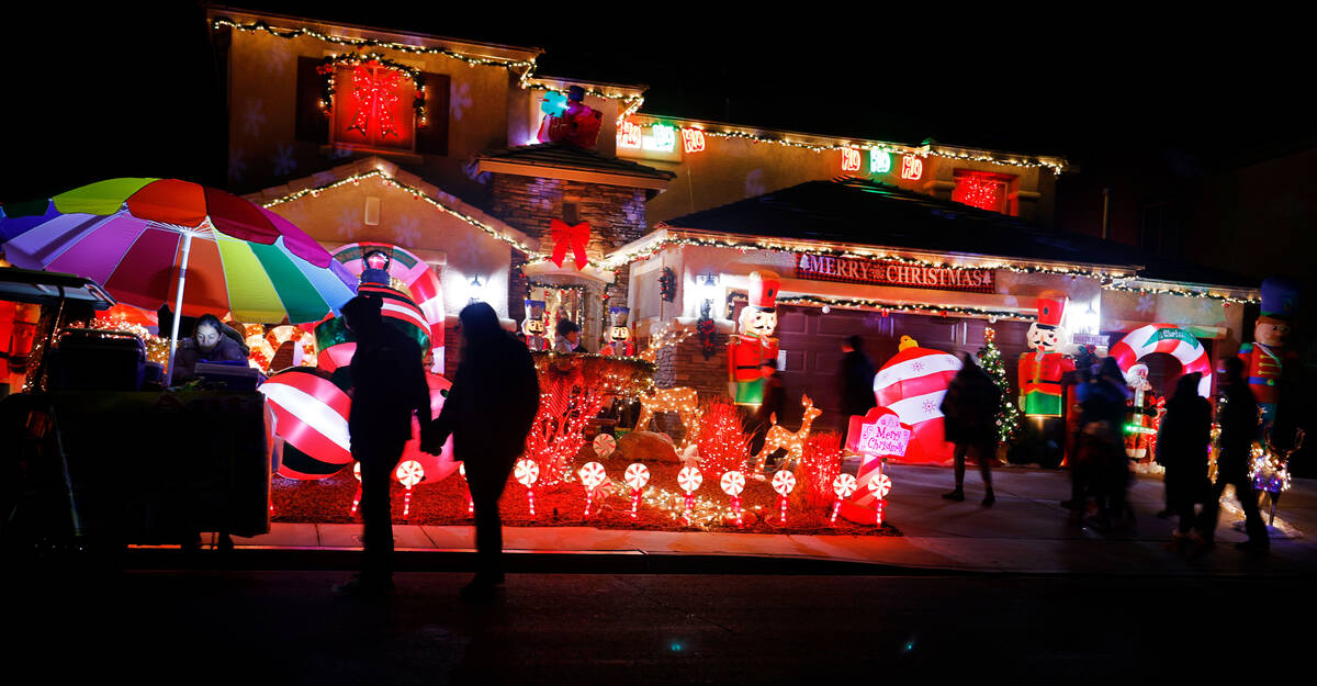 People visit the Candy Cane House, Friday, Dec. 16, 2022, in Henderson. Victor Cardenas and his ...