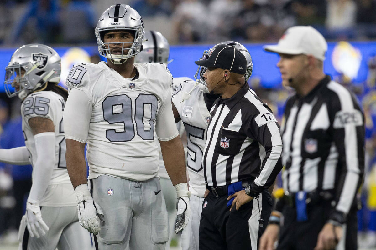 Raiders defensive tackle Jerry Tillery (90) reacts to being flagged on a play with field judge ...