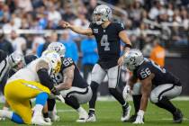 Raiders quarterback Derek Carr (4) audibles at the line of scrimmage with center Andre James (6 ...