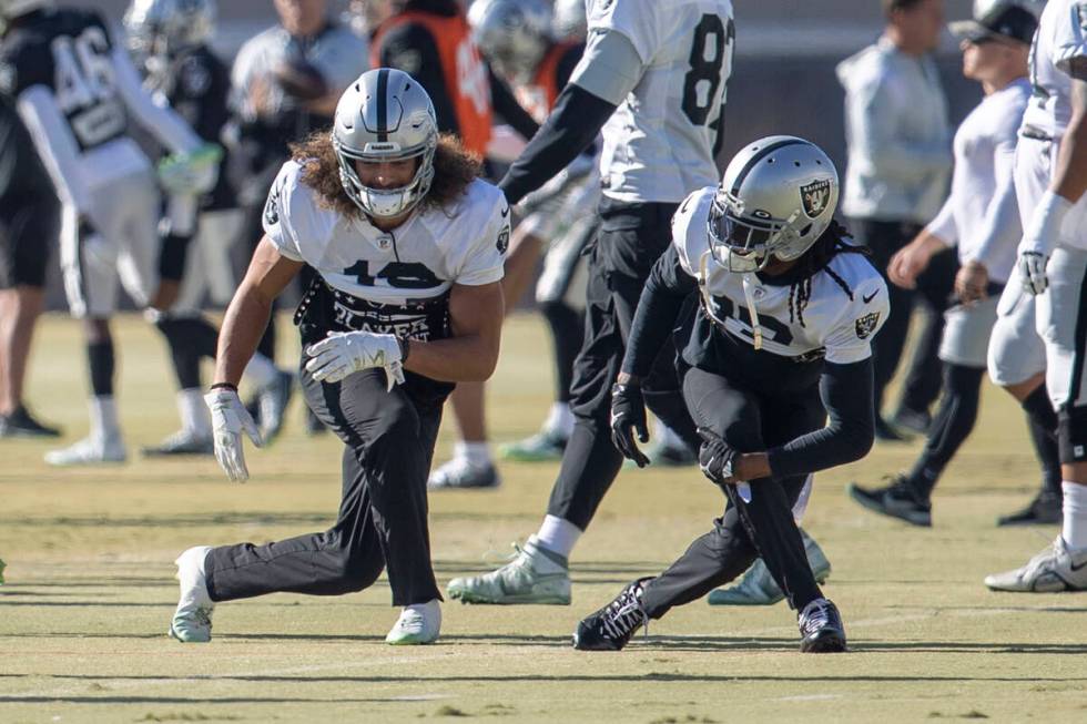Raiders wide receiver Mack Hollins (10), left, and Davante Adams (17) stretch during practice a ...