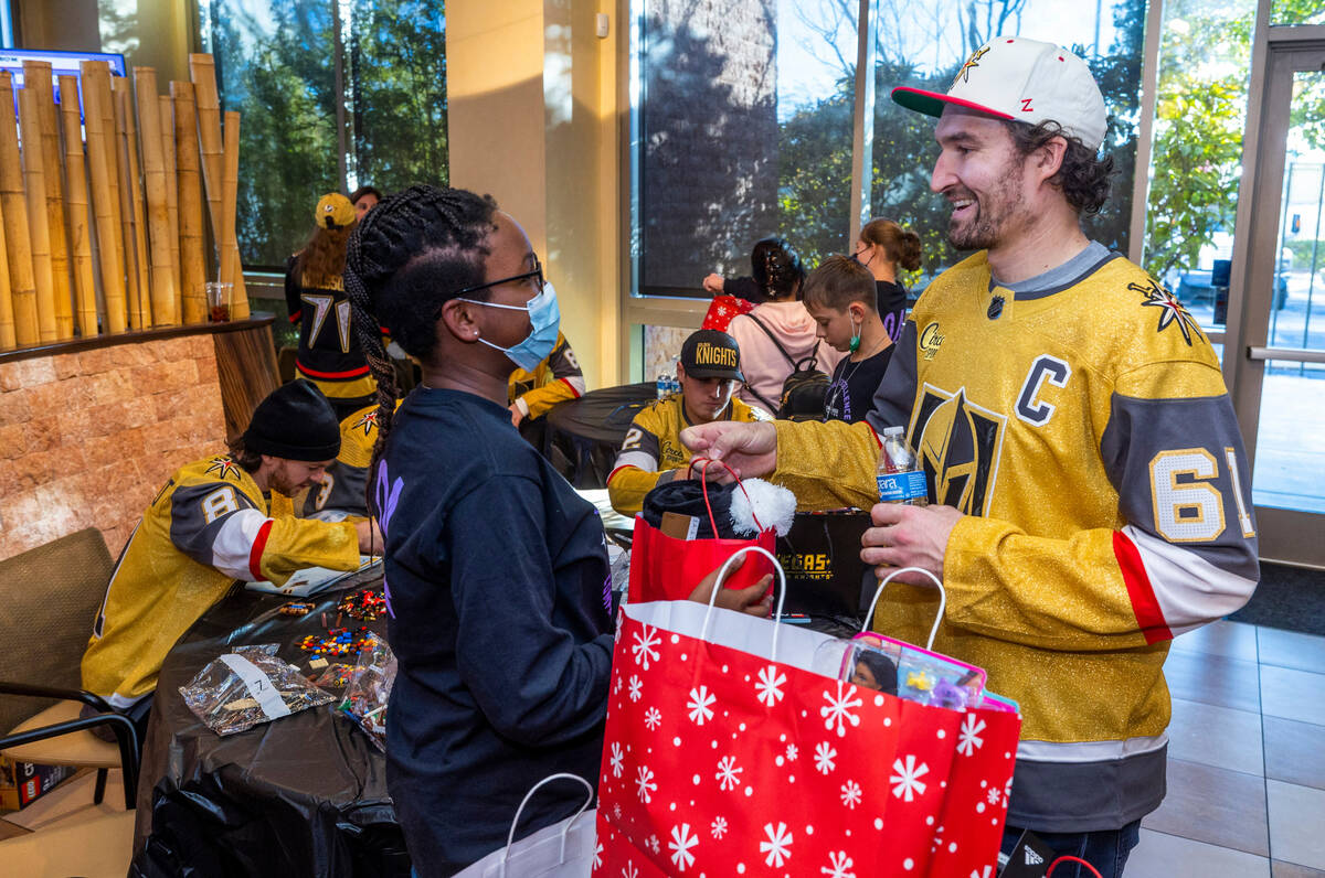 Patient McKinley Eisenberg, 12, is given a gift bag by Mark Stone (61) as the Cure 4 The Kids F ...