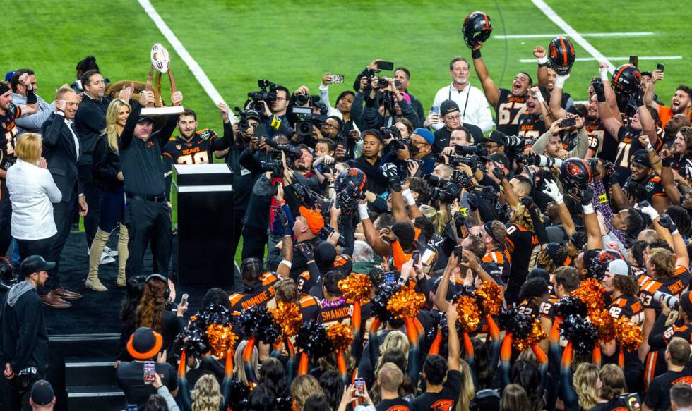 Oregon State Beavers Head Coach Jonathan Smith holds up the Rossi Ralenkotter trophy after his ...