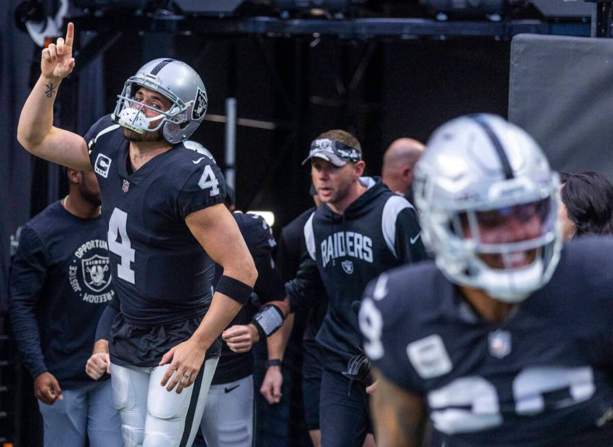 Raiders quarterback Derek Carr (4) points to the heavens while entering the field during warm u ...