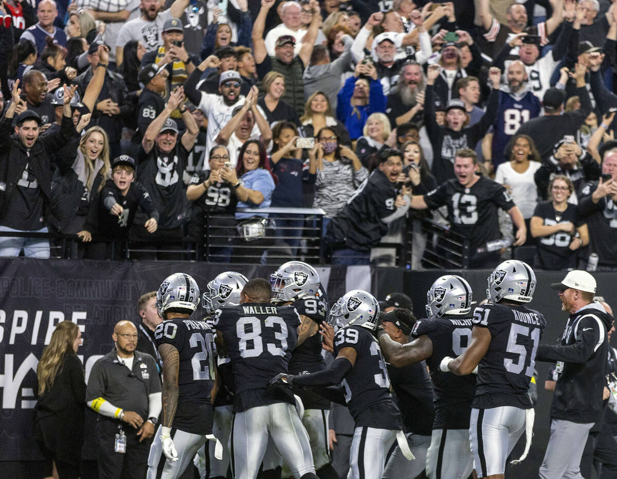 Raiders players celebrate a score by teammate defensive end Chandler Jones (55) to beat the New ...