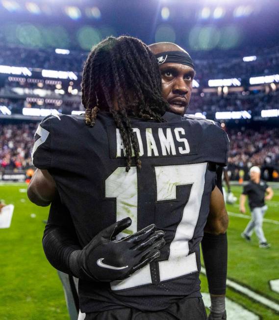 Raiders defensive end Chandler Jones (55) is hugged by teammate wide receiver Davante Adams (17 ...