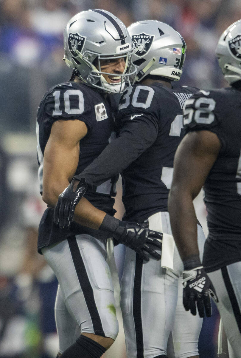 Raiders wide receiver Mack Hollins (10) celebrates with safety Duron Harmon (30) after downing ...