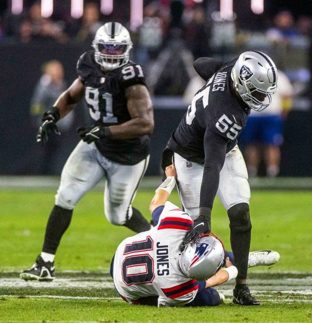 Raiders defensive end Chandler Jones (55) drives New England Patriots quarterback Mac Jones (10 ...