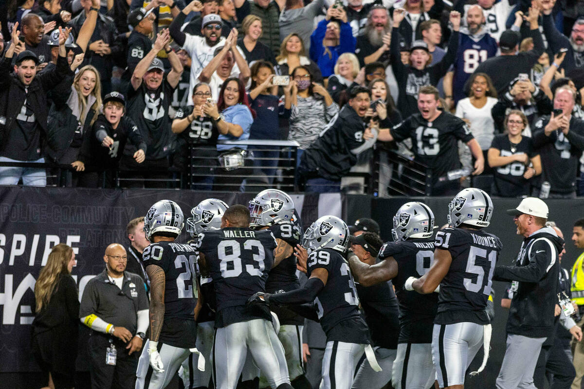 Raiders players celebrate a score by teammate defensive end Chandler Jones (55) to beat the New ...