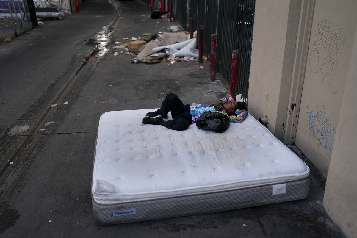 FILE - A homeless man sleeps on a discarded mattress in Los Angeles, Thursday, July 21, 2022. O ...