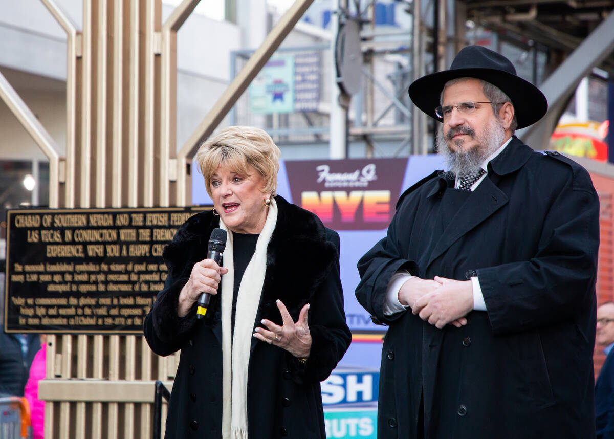 Mayor Carolyn Goodman, left, and Rabbi Shea Harlig, right, from Chabad of Southern Nevada, give ...