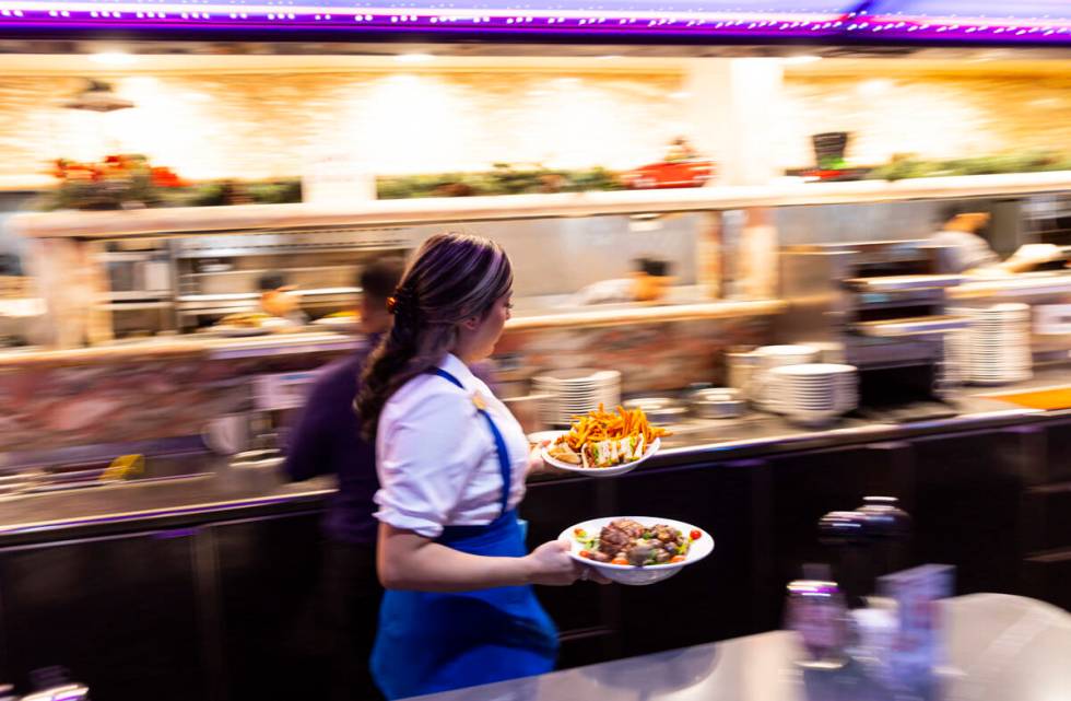 A waitress brings out dishes at Peppermill on Wednesday, Dec. 14, 2022, in Las Vegas. The famed ...