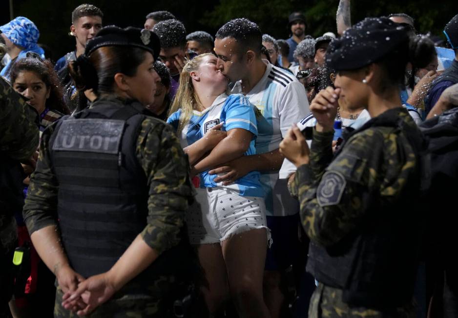 Fans kiss while waiting for the arrival of the Argentine soccer team that won the World Cup out ...