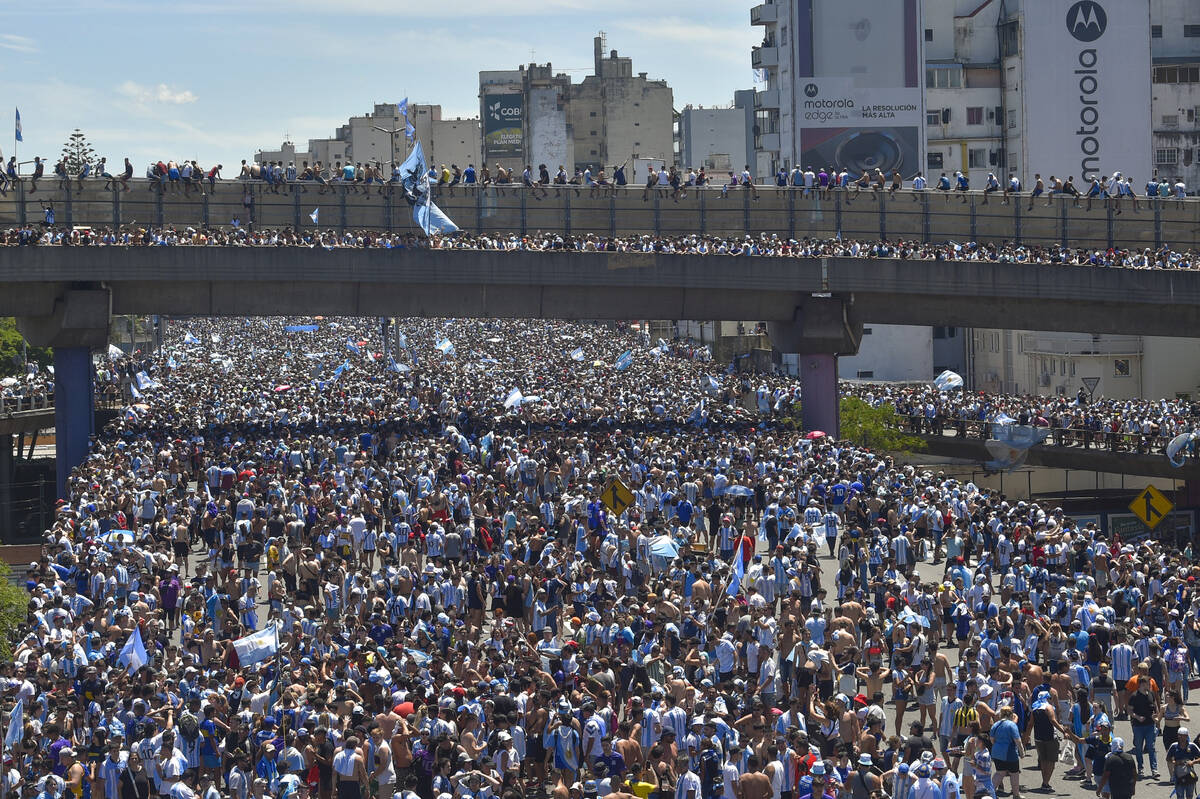 Argentina soccer fans crowd a highway for a homecoming parade for the players who won the World ...