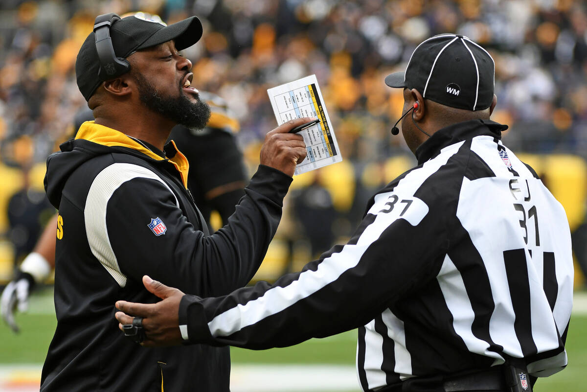 Pittsburgh Steelers head coach Mike Tomlin, left, talks with line judge Tripp Sutter (37) durin ...