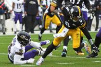 Pittsburgh Steelers quarterback Kenny Pickett (8) slips out of the grasp of Baltimore Ravens li ...