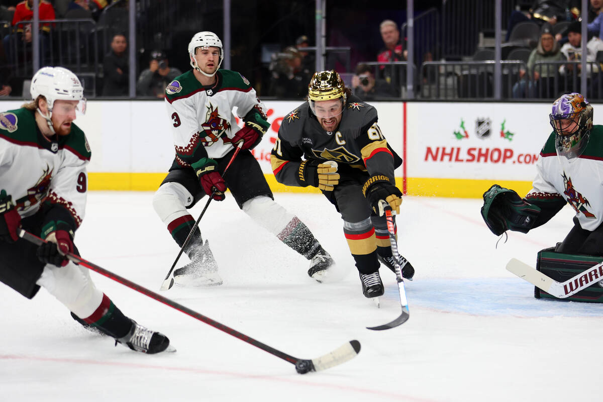 Vegas Golden Knights right wing Mark Stone (61) fights for the puck against Arizona Coyotes rig ...