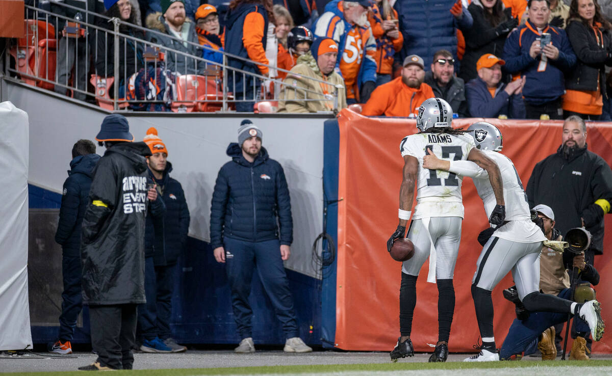 Raiders wide receiver Davante Adams (17) and quarterback Derek Carr (4) run into the tunnel aft ...