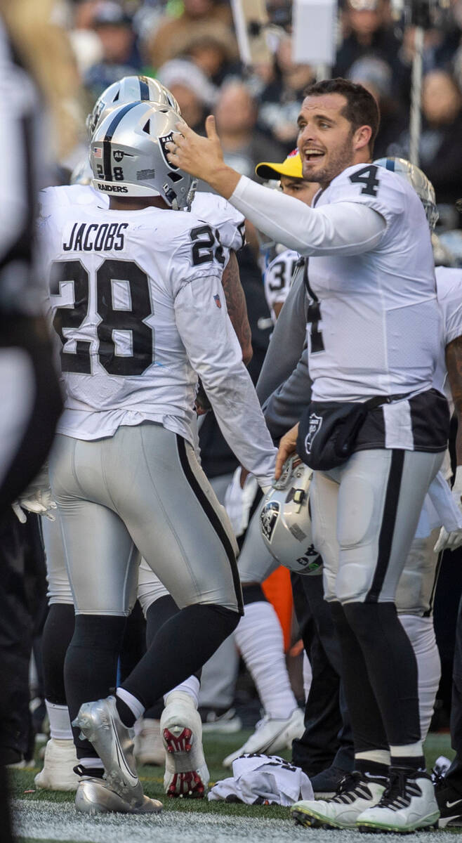 Raiders quarterback Derek Carr (4) congratulates running back Josh Jacobs (28) during the first ...