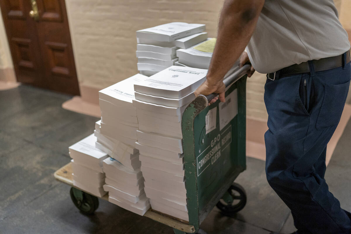 Stacks of the Congressional Record are distributed as lawmakers debate a massive $1.7 trillion ...