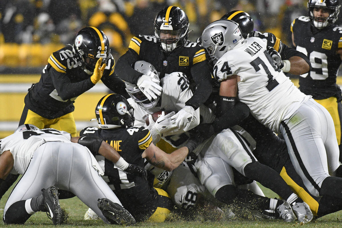 Las Vegas Raiders running back Josh Jacobs (28) is gang tackled during the second half of an NF ...