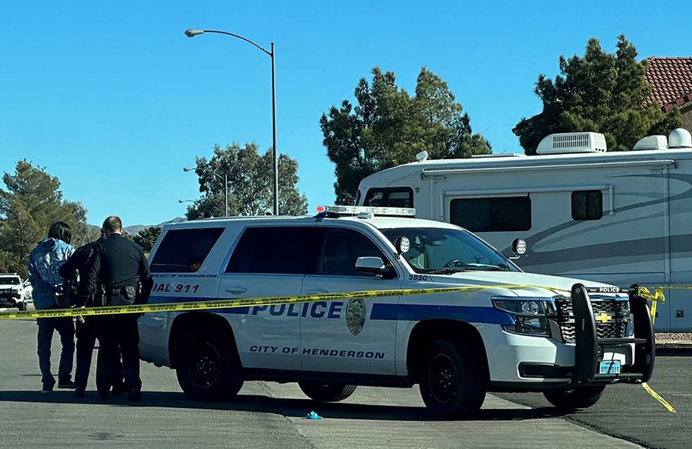 Police take a male into custody after a police officer shot a male on Dec. 25, 2022. The shooti ...