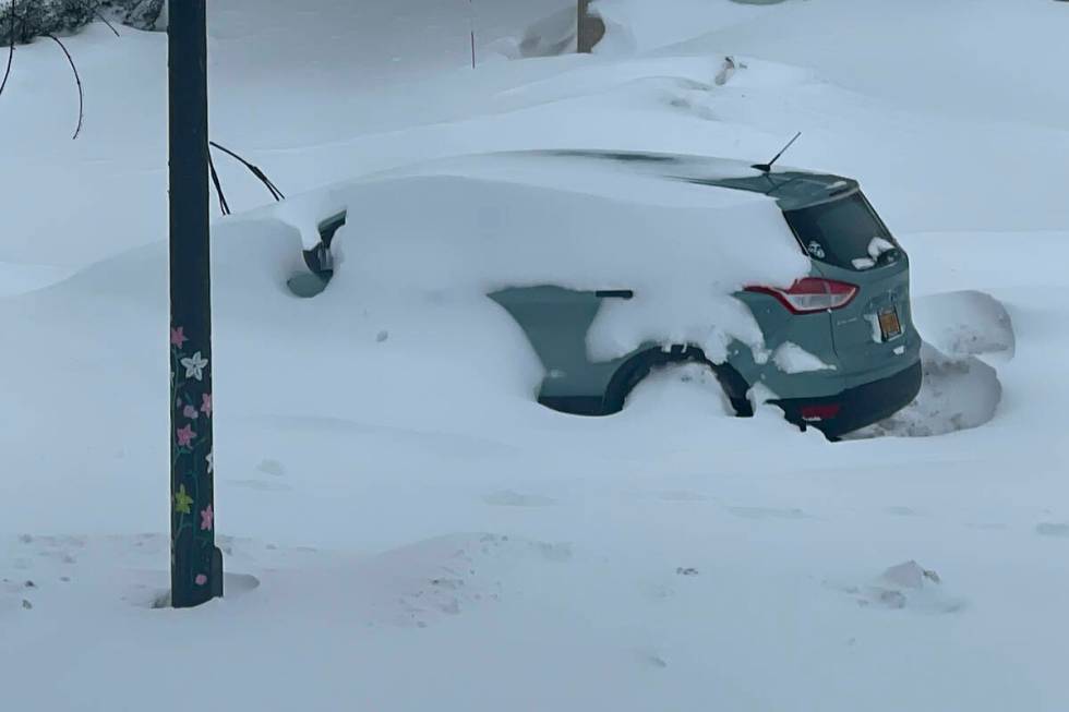 A car sits immobile and blanketed in snow, Sunday, Dec. 25, 2022, in Buffalo, N.Y. Millions of ...