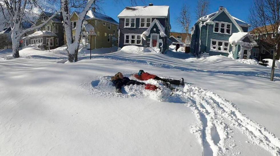 This photo provided by Clare Purcell shows two people making snow angels after a snowstorm in B ...