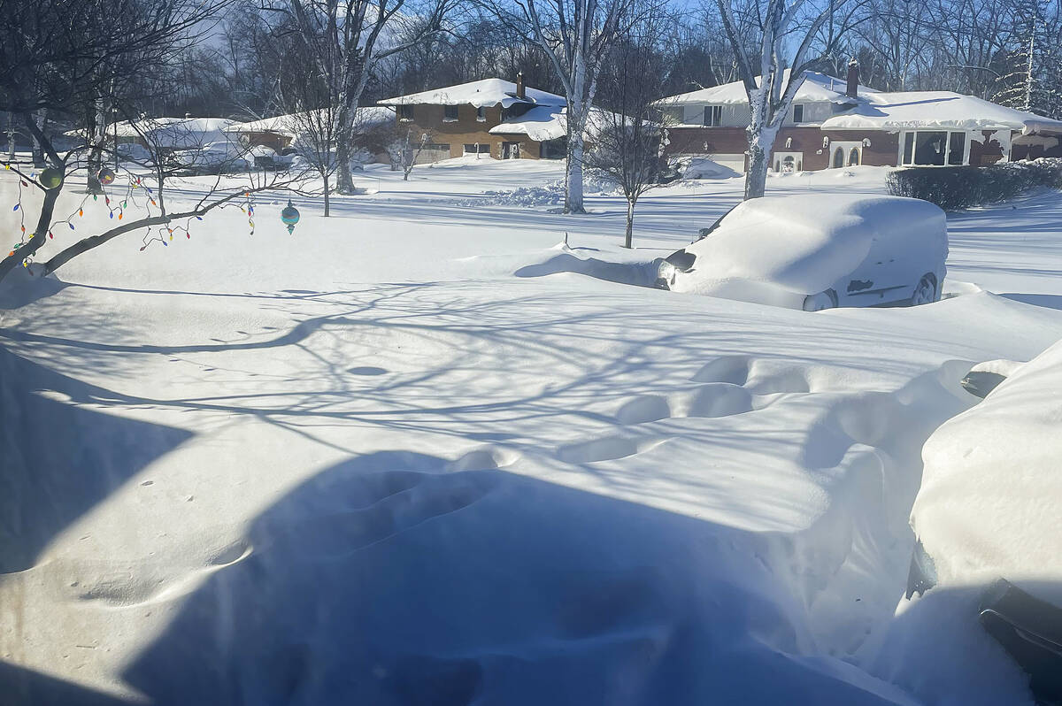 A car sits blanketed in snow on a driveway, Sunday, Dec. 25, 2022, in Amherst, N.Y. Millions of ...