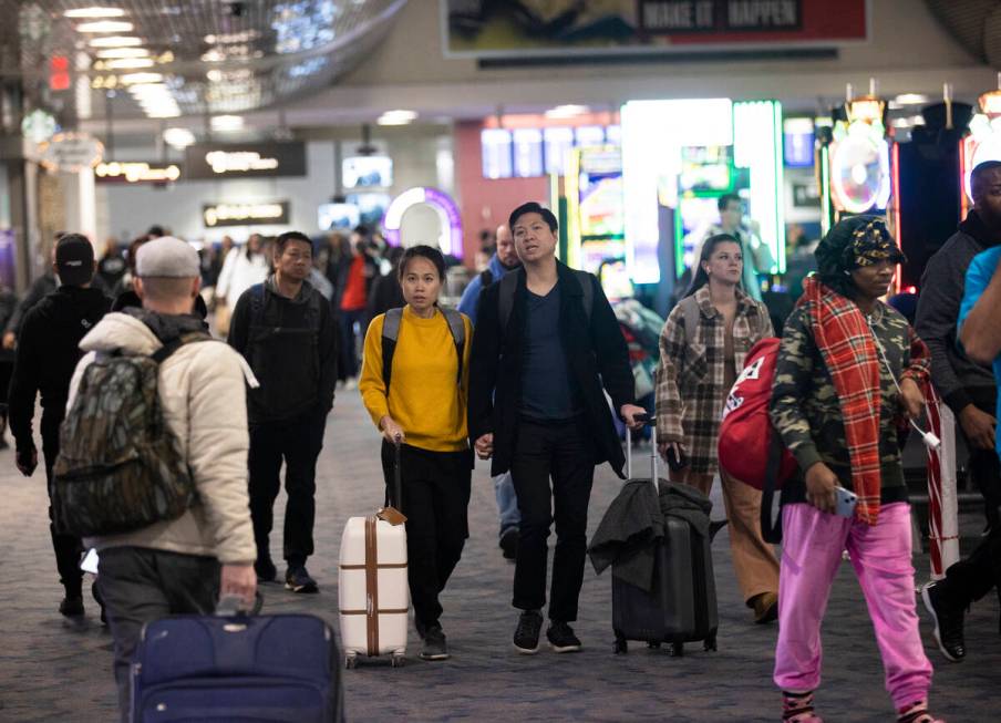 Travelers walk through terminal 1 at Harry Reid International Airport on Sunday, Nov. 27, 2022, ...