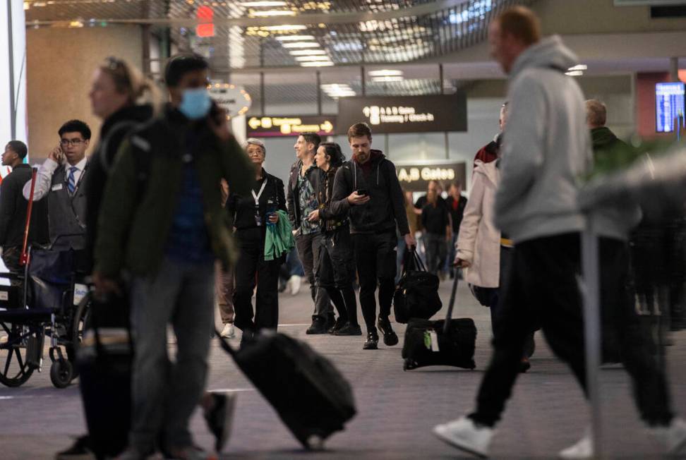 Travelers walk through terminal 1 at Harry Reid International Airport on Sunday, Nov. 27, 2022, ...