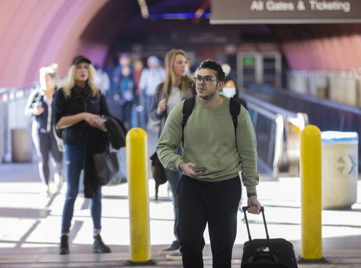 Travelers walk through terminal 1 at Harry Reid International Airport on Sunday, Nov. 27, 2022, ...