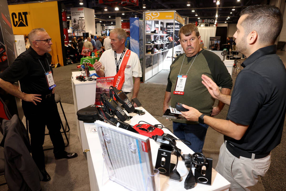 Irving Delgado of Innova Electronics in Irvine, Calif. shows a diagnostic tool to Rodney Moon o ...