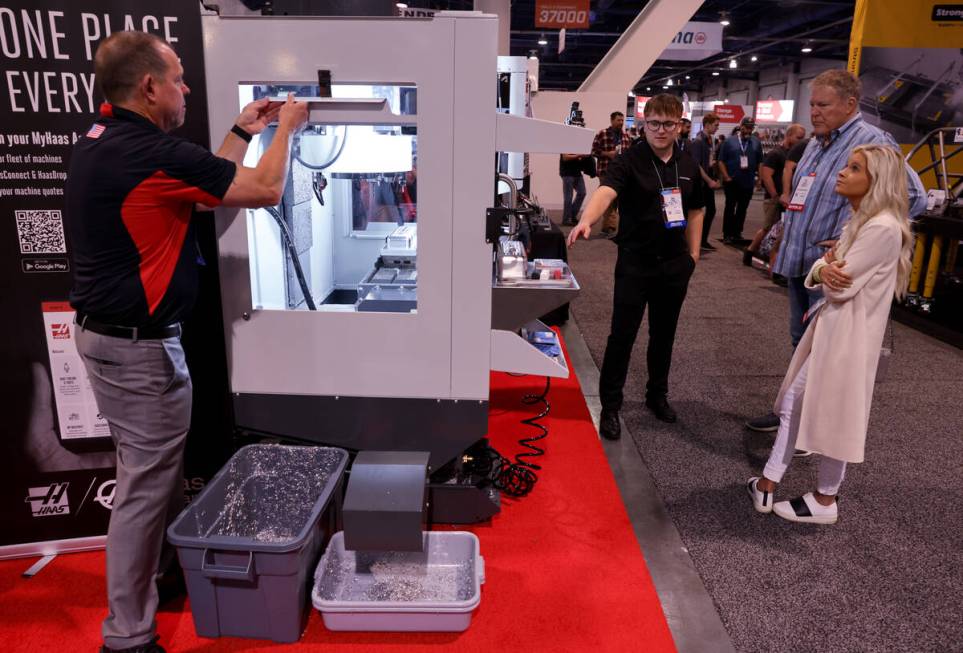 Josh Reader of Haas Automation in Oxnard, Calif. shows a machine tool to Pete Gulick and Chloe ...