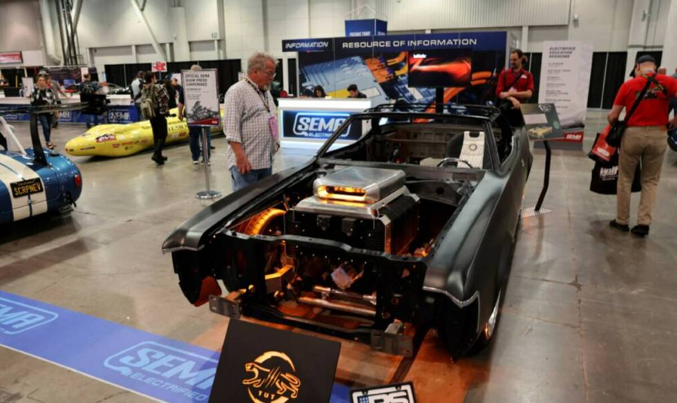 Conventioneers check out an all electric Mercury Cougar in the SEMA Electrified section on Day ...