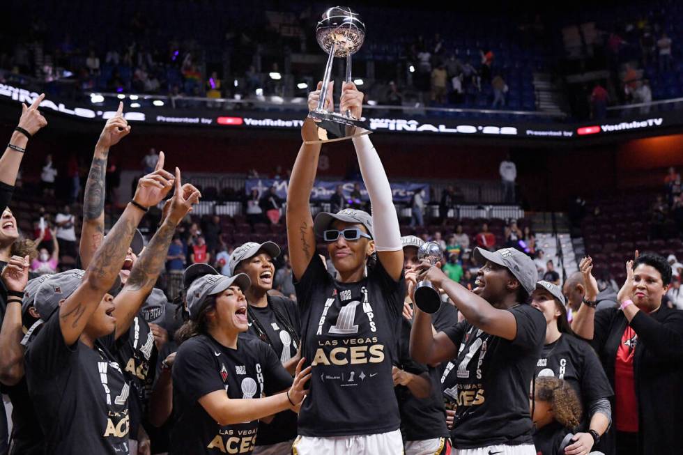 Las Vegas Aces' A'ja Wilson holds up the championship trophy as she celebrates with her team th ...