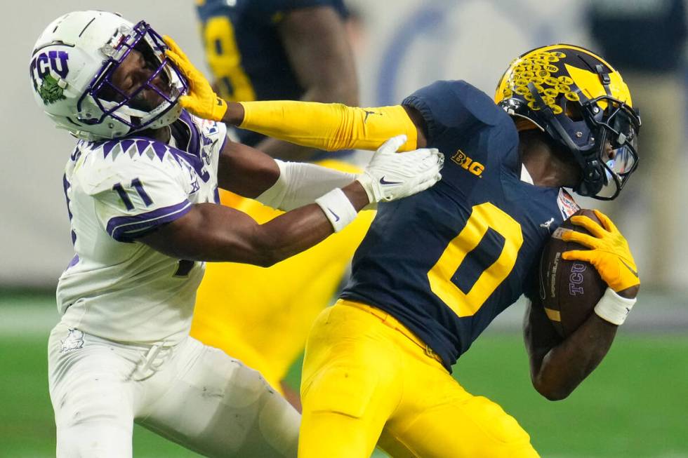 Michigan defensive back Mike Sainristil (0) intercepts a pass intended for TCU wide receiver De ...