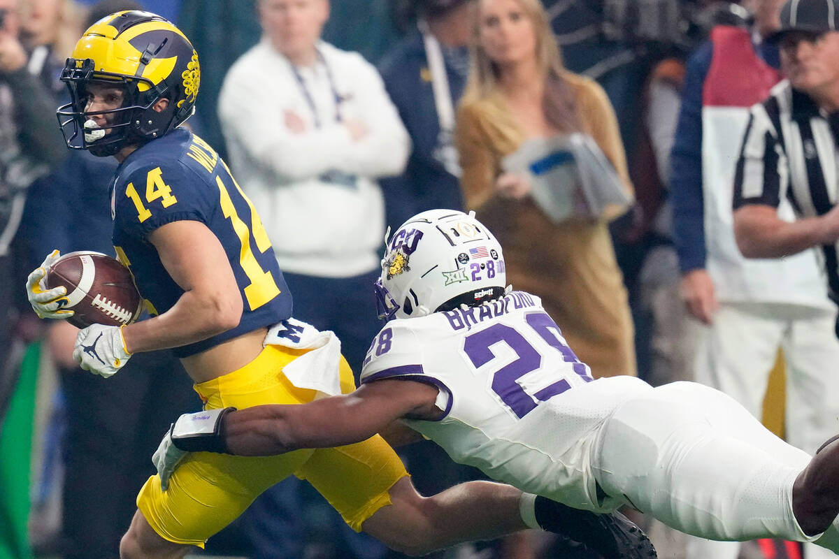 Michigan wide receiver Roman Wilson (14) is tackled by TCU safety Millard Bradford (28) during ...