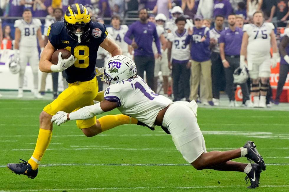 Michigan tight end Colston Loveland (18) is hit by TCU linebacker Dee Winters (13) during the f ...