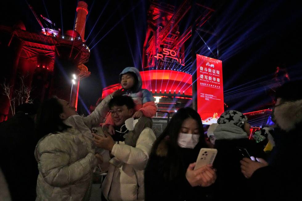 Revellers take photos after a count down to the new year at the Shougang Park in Beijing, Sunda ...