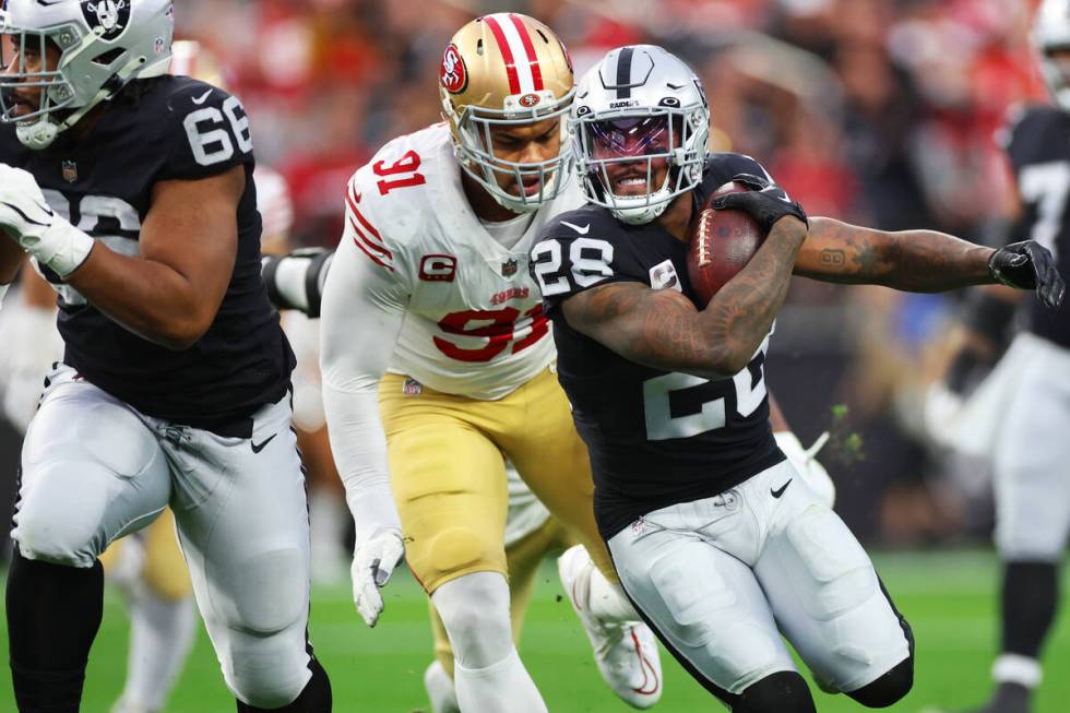 Raiders running back Josh Jacobs (28) runs the ball past San Francisco 49ers safety Tashaun Gip ...