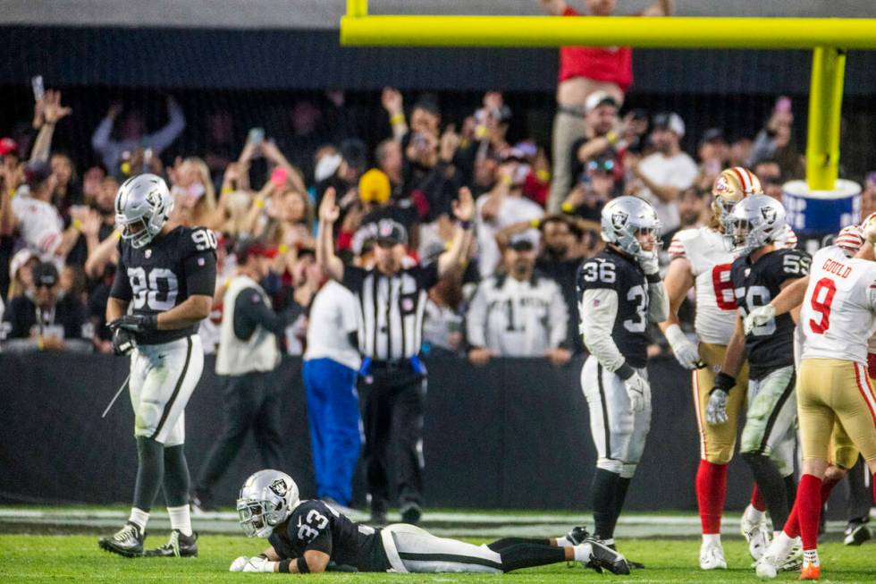 Raiders safety Roderic Teamer (33) lies dejected on the turf amongst teammates as the San Franc ...