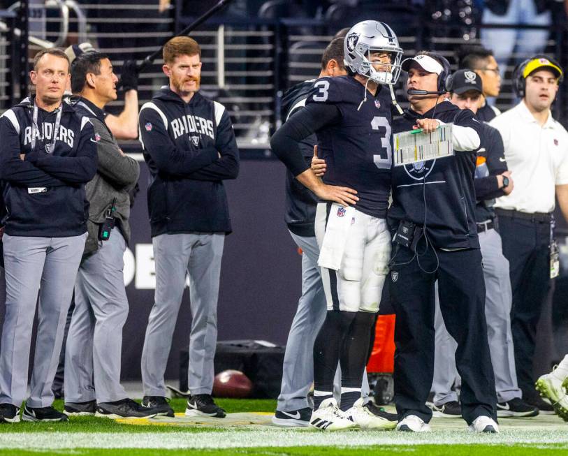 Raiders quarterback Jarrett Stidham (3) is counseled on the sidelines by Head Coach Josh McDani ...