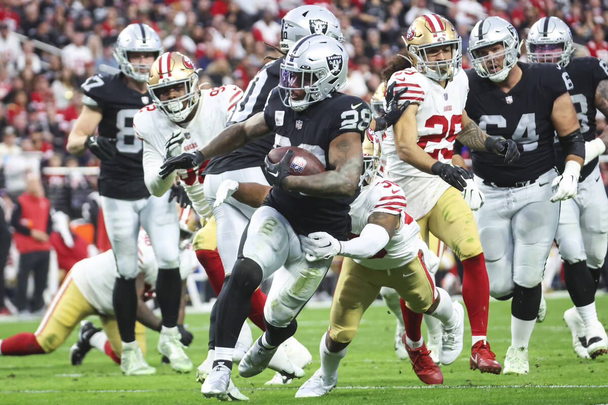 Raiders running back Josh Jacobs (28) runs the ball against the San Francisco 49ers during the ...