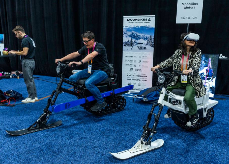 Pete Woman and Gaelle Van Hieu check out a pair of MoonBikes during the CES Unveiled media days ...